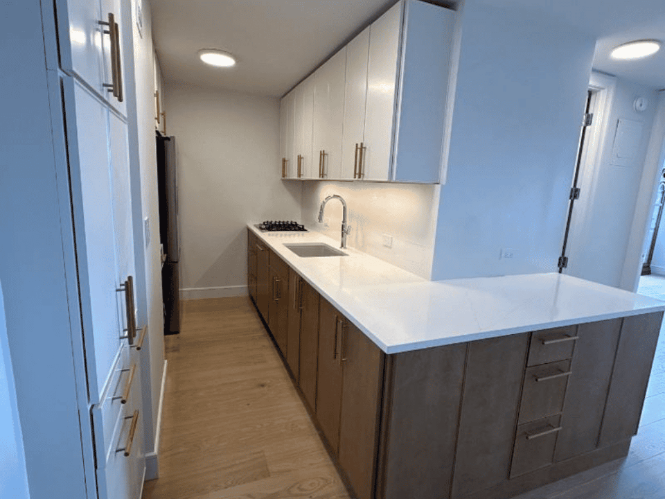 Kitchen remodel with a wrap-around counter and under cabinet lighting by Modo Renovations