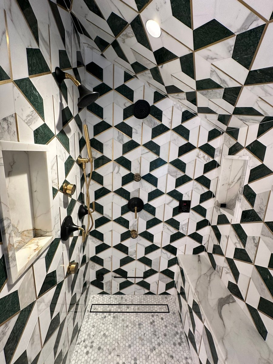 completed shower wall with brass fixtures and patterned tile by modo renovations in rye ny home remodel