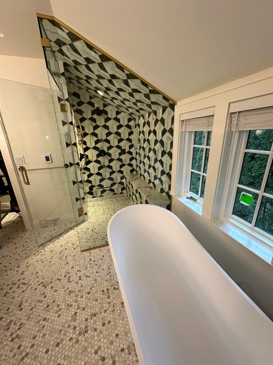 freestanding bathtub with patterned accent wall and windows by modo renovations in rye ny home remodel