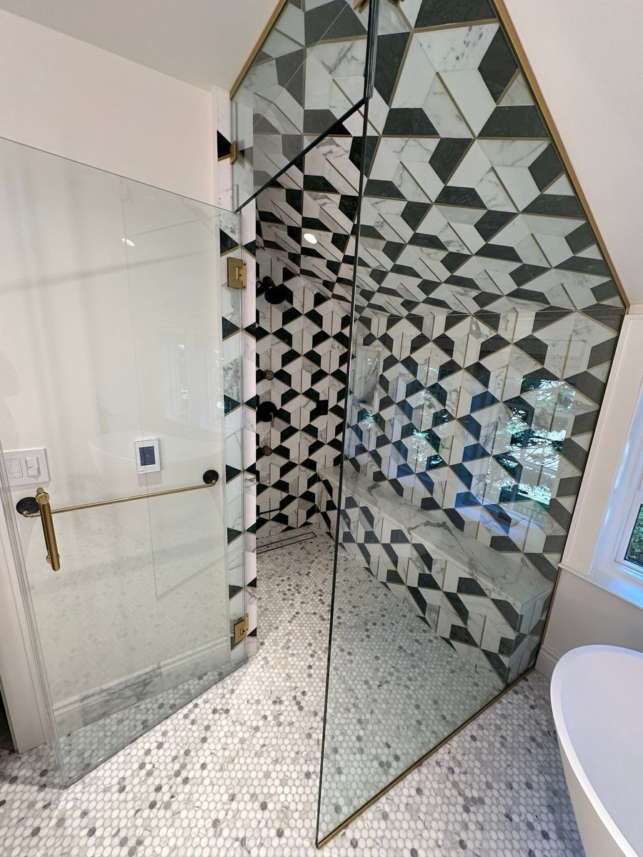 glass shower doors with brass hardware and patterned tile by modo renovations in rye ny home remodel